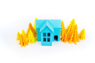 Mavi Ev kağıdımız yapıştırılmış sarı ormanda duruyor. Beyaz arka plan. Çocuk el sanatları. Noel ağacı.