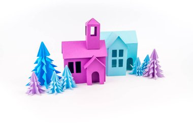 Dışarı-in kağıt yapıştırılmış ev mor ve mavi menekşe ormanda duruyor. Beyaz arka plan. Çocuk el sanatları. Noel ağacı.