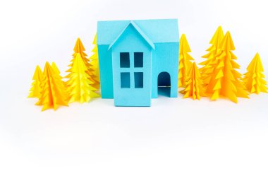 Mavi Ev kağıdımız yapıştırılmış sarı ormanda duruyor. Beyaz arka plan. Çocuk el sanatları. Noel ağacı.