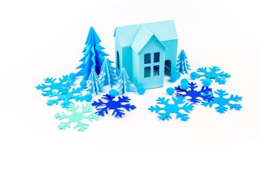 Mavi Ev kağıdımız yapıştırılmış menekşe ormanda duruyor. Beyaz arka plan. Çocuk el sanatları. Noel ağacı. Kartopu ve kar tanesi