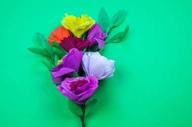 Kapkacak ve aletleri krep kağıt çiçekler üzerinde yeşil arka plan yapmak için. Cosmos çiçek buketi