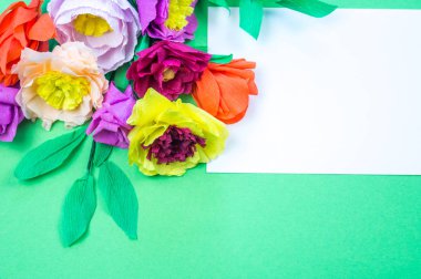 Kapkacak ve aletleri krep kağıt çiçekler üzerinde yeşil arka plan yapmak için. Cosmos çiçek buketi