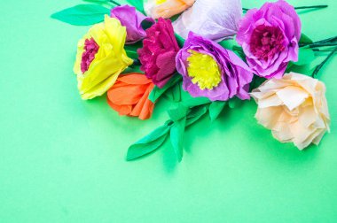 Kapkacak ve aletleri krep kağıt çiçekler üzerinde yeşil arka plan yapmak için. Cosmos çiçek buketi