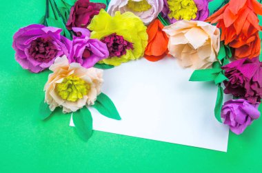 Kapkacak ve aletleri krep kağıt çiçekler üzerinde yeşil arka plan yapmak için. Cosmos çiçek buketi