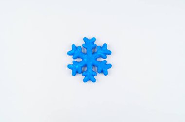 Kar tanesi köpük boya ile boyanmış. Gökkuşağı renkleri. Beyaz arka plan. Hobiler yaratıcılık çocuklar için.