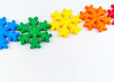 Kar tanesi köpük boya ile boyanmış. Gökkuşağı renkleri. Beyaz arka plan. Hobiler yaratıcılık çocuklar için.