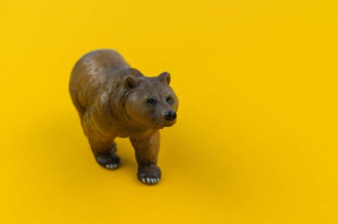 Sarı bir arka plan üzerinde plastik oyuncak ayı. Bir çocuk için orman hayvan.