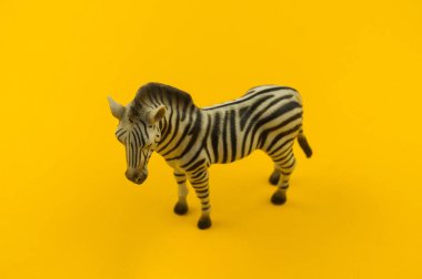 Sarı bir arka plan üzerinde plastik oyuncak zebra. Hayvanlarıyla bir çocuk için. Yazmak için bir yer.