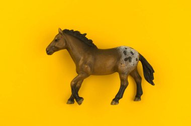 Sarı bir arka plan üzerinde plastik oyuncak at. Hayvan çiftlik çocuk için. Evde beslenen hayvan artiodactyl.