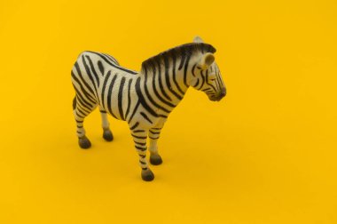 Sarı bir arka plan üzerinde plastik oyuncak zebra. Hayvanlarıyla bir çocuk için. Yazmak için bir yer.