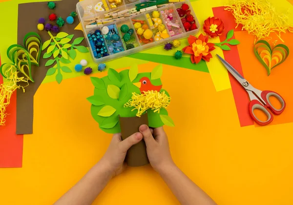 Dziecko robi drzewo rzemiosła papieru. Pomarańczowe tło i materiały do zajęć kreatywnych. — Zdjęcie stockowe