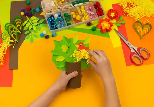 Kind bastelt Baum aus Papier. orangefarbener Hintergrund und Materialien für Kreativkurse. — Stockfoto