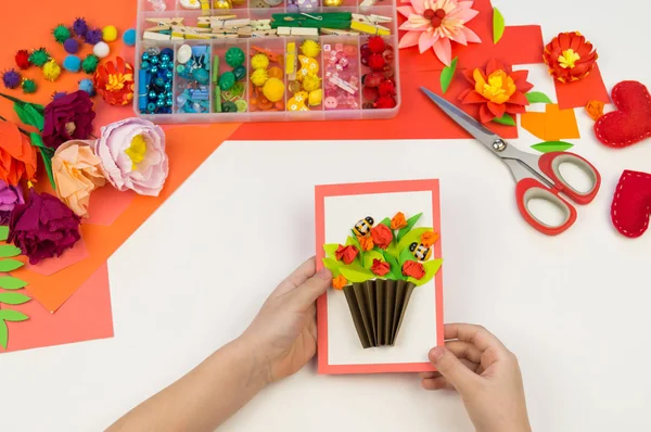 Kind macht eine Postkarte flach. Geschenk für Mutter ein Feiertag am 8. März. — Stockfoto