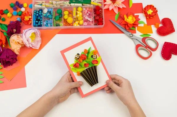 Kind macht eine Postkarte flach. Geschenk für Mutter ein Feiertag am 8. März. — Stockfoto