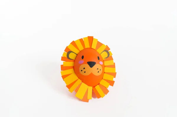 Easter holiday concept with cute handmade eggs: a lion.