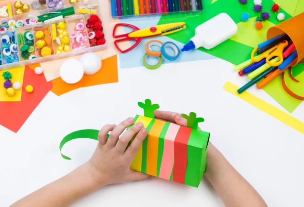 Barn gör en hacka låda kameleont. Material för kreativitet på vit bakgrund. — Stockfoto