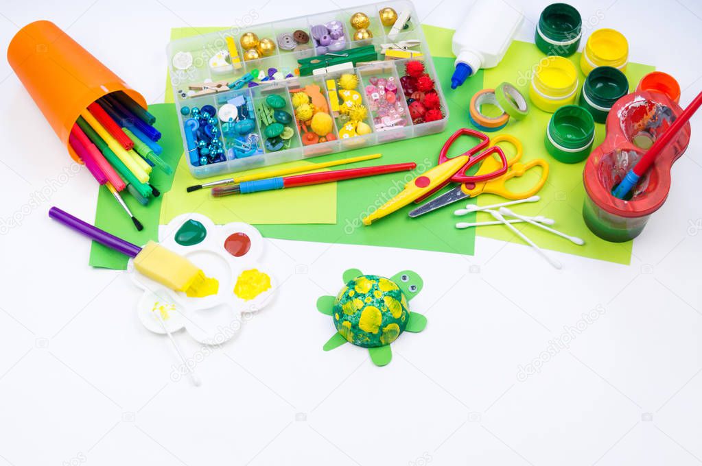 The child makes a craft toy from foam plastic tortoise. Material for creativity and education.