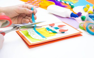 Çocuk pasta resmi olan bir kartpostal yapar. Çocuk evrak.