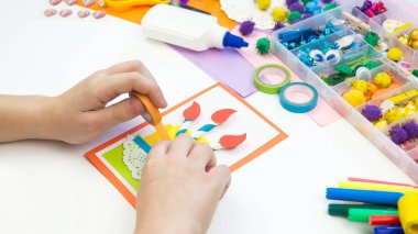 Çocuk pasta resmi olan bir kartpostal yapar. Çocuk evrak.