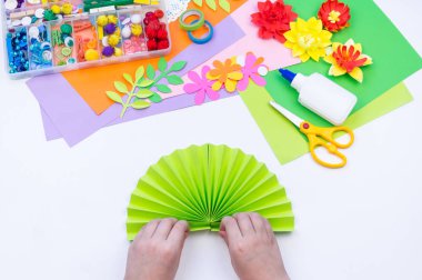 Çocuk bahar tatili için anneye bir hediye yapar. Kağıttan yapıştırılmış çiçek.