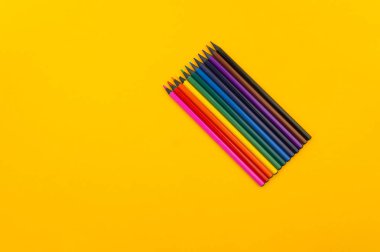 Sarı bir arka plan üzerinde siyah ahşap kalem. Abanoz kalemler.