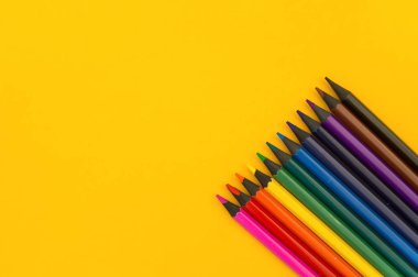 Sarı bir arka plan üzerinde siyah ahşap kalem. Abanoz kalemler.