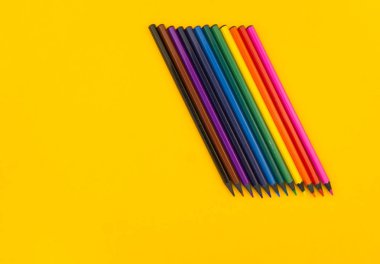 Sarı bir arka plan üzerinde siyah ahşap kalem. Abanoz kalemler.