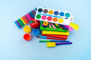 Okulda eğitim için kırtasiye mavi yatıyor. Okula geri dön. Gökkuşağı rengi