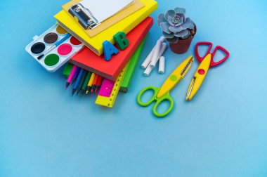 Okulda eğitim için kırtasiye mavi yatıyor. Okula geri dön. Çiçek sulu.