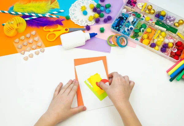 El niño hace una postal con una foto de un pastel. Papeleo infantil . — Foto de Stock