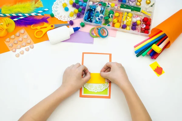 Gyermek tesz egy képeslapot egy képet egy tortát. Gyerek papírmunka. — Stock Fotó