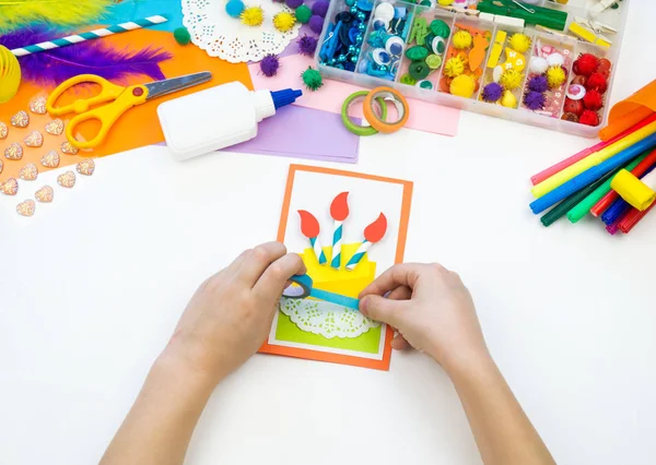Child makes a postcard with a picture of a cake. Kid paperwork. — Stock Photo, Image