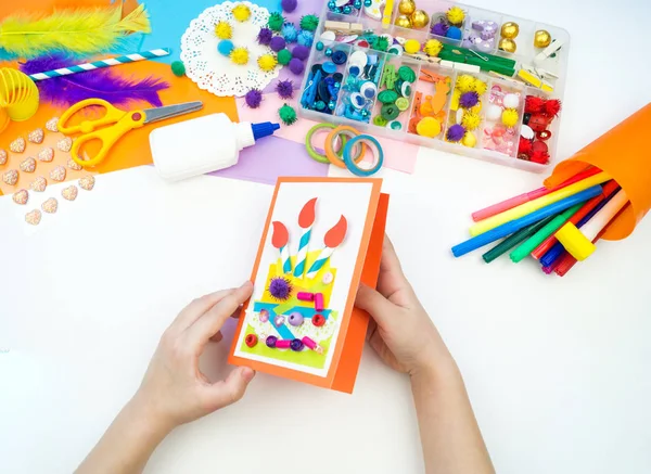 Ein Kind bastelt eine Postkarte mit einem Bild von einem Kuchen. Papierkram für Kinder. — Stockfoto