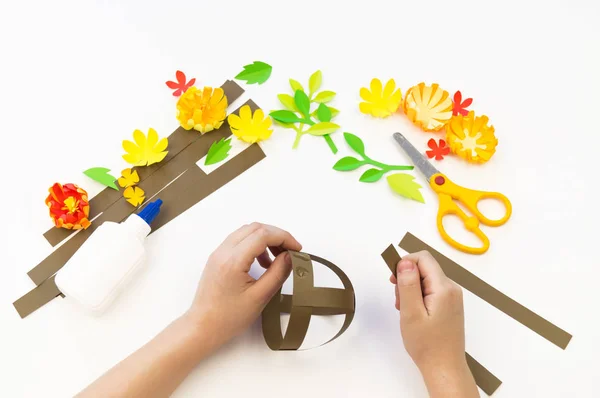 Kid sticks a basket out of paper. Holiday Easter. — Stock Photo, Image