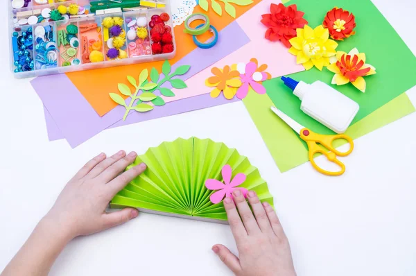 Child makes a gift to mother for the holiday of spring. Flower glued from paper. — Stock Photo, Image