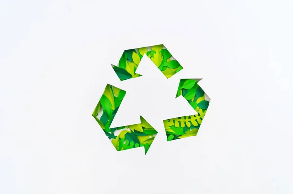 Grüne Farbe Recycling-Schild aus Papierblättern. Tropenpflanze geschnitten. — Stockfoto