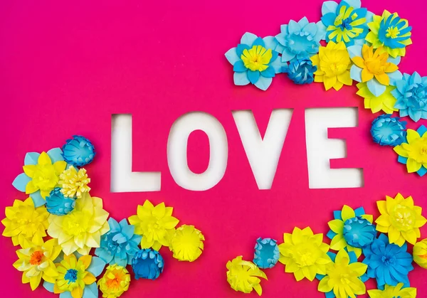 Inscriptie liefde gesneden uit papier. Roze achtergrond. Bloem gemaakt van papier. — Stockfoto