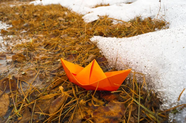 A boat made of colored paper in the snow. Origami handicraft. — Stock Photo, Image