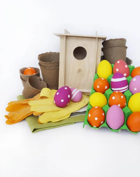 Decorative Easter composition. Birdhouse and Easter eggs. Flowerpots