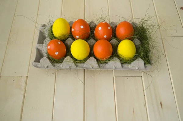 Ljusa påsk. Grönt gräs. Gula och orange ägg. Trä bakgrund. — Stockfoto