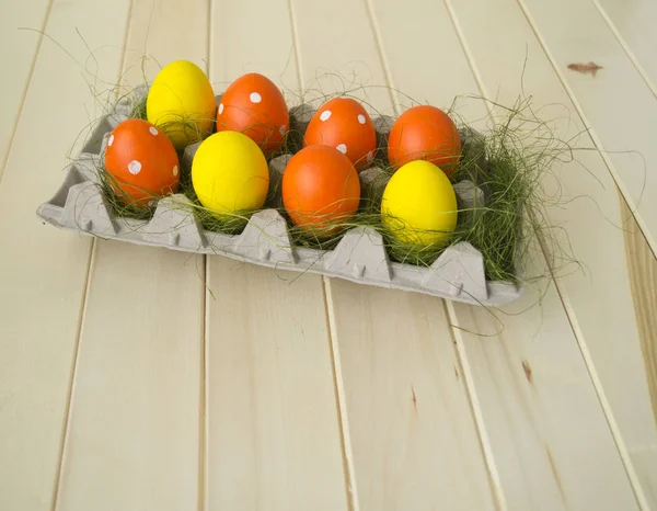 Ljusa påsk. Grönt gräs. Gula och orange ägg. Trä bakgrund. — Stockfoto