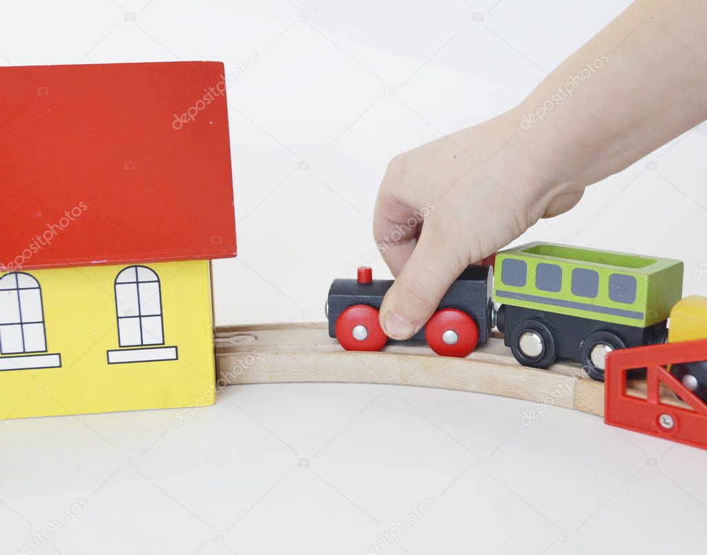 Children's toy. The child rolls a wooden locomotive. Iron and wooden road.