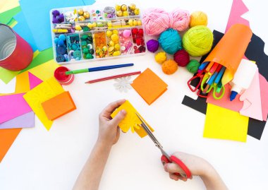 çocuk kağıttan bir çiçek keser. Origami kağıt plastik. Favori hobi oyuncak.