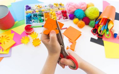 çocuk kağıttan bir çiçek keser. Origami kağıt plastik. Favori hobi oyuncak.