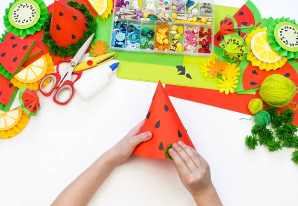 Papierdeckel diy für Fruchtparty. Wassermelonen-Geburtstag. Kinderhände basteln. — Stockfoto