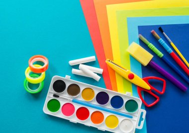 Okulda eğitim için kırtasiye mavi yatıyor. Okula geri dön. Gökkuşağı rengi