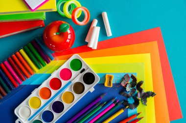 Okulda eğitim için kırtasiye mavi yatıyor. Okula geri dön. Gökkuşağı rengi