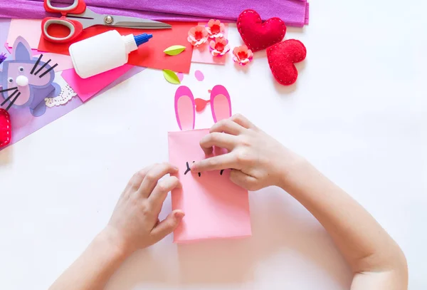 Детские руки делают коробочного кролика. Праздничный пасхальный свет. Материал для творчества. hand people — стоковое фото