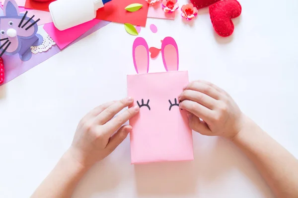 Детские руки делают коробочного кролика. Праздничный пасхальный свет. Материал для творчества. hand people — стоковое фото