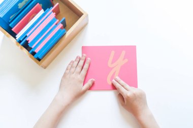 Montessori malzemesi. Çocukların elleri. Mektup ve kelimelerin incelenmesi. Kaba alfabe işgali